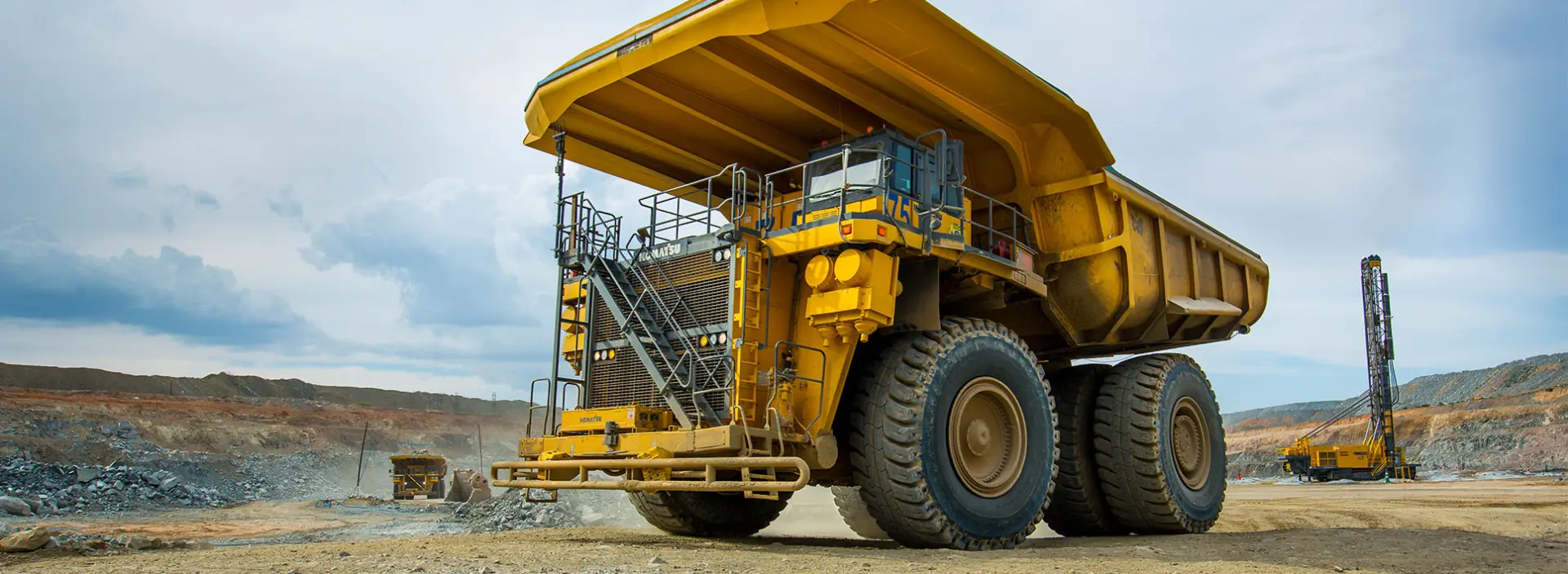  Large yellow mining haul truck powered by a diesel engine working in an open-pit mine