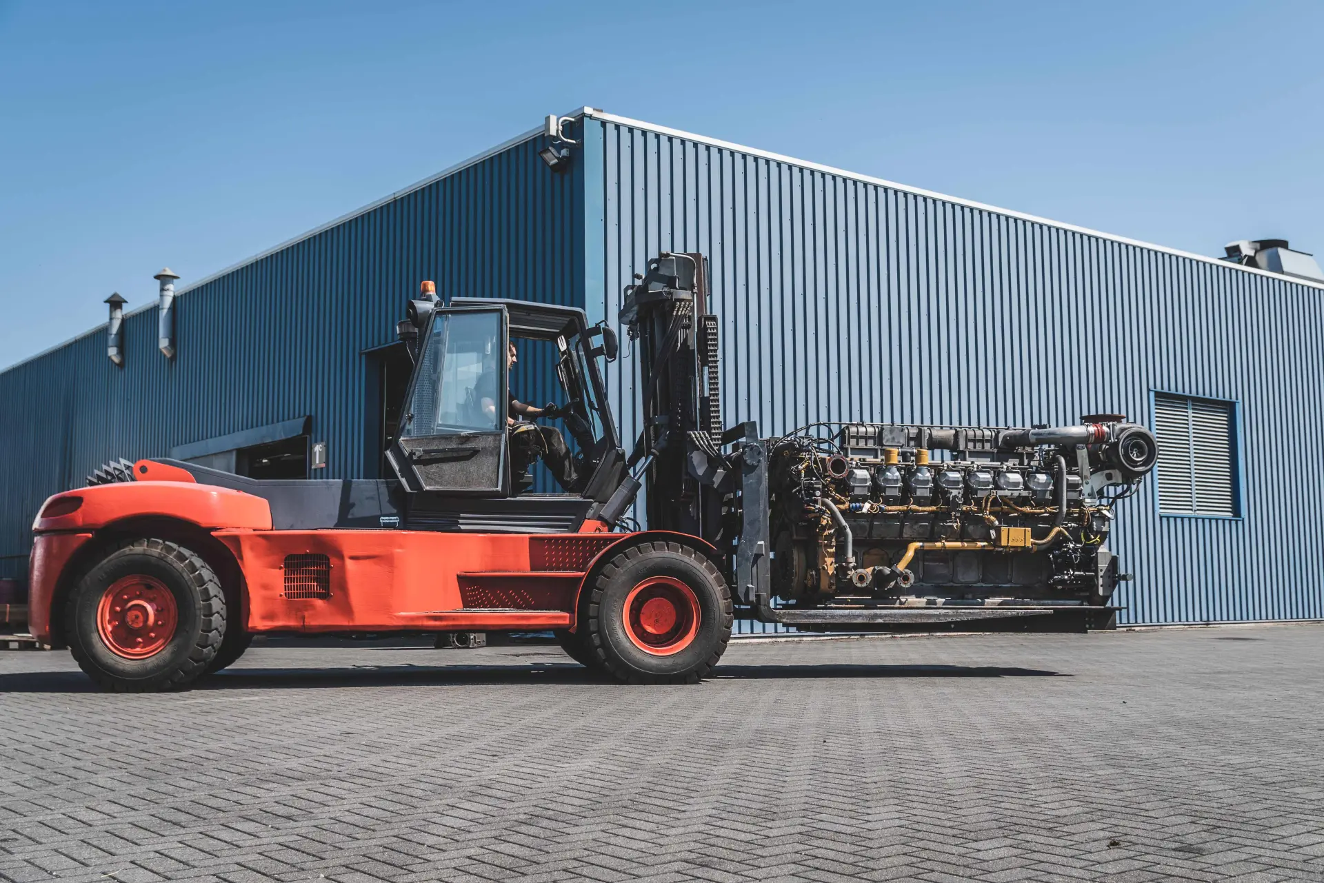 Forklift moving a large industrial diesel engine at the Hamofa Industrial Engines site